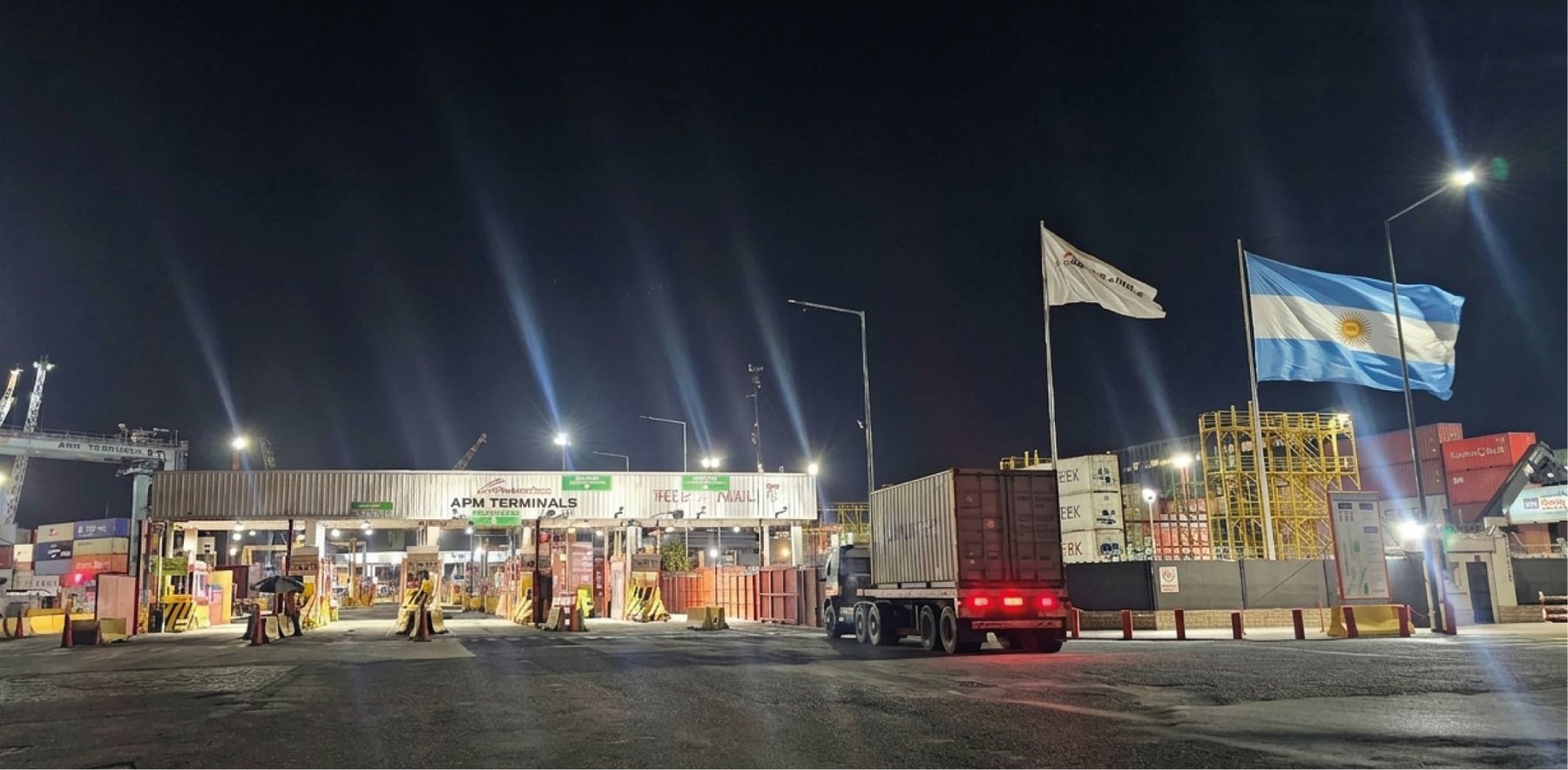 Camión con contenedor en el acceso de APM Terminals de noche